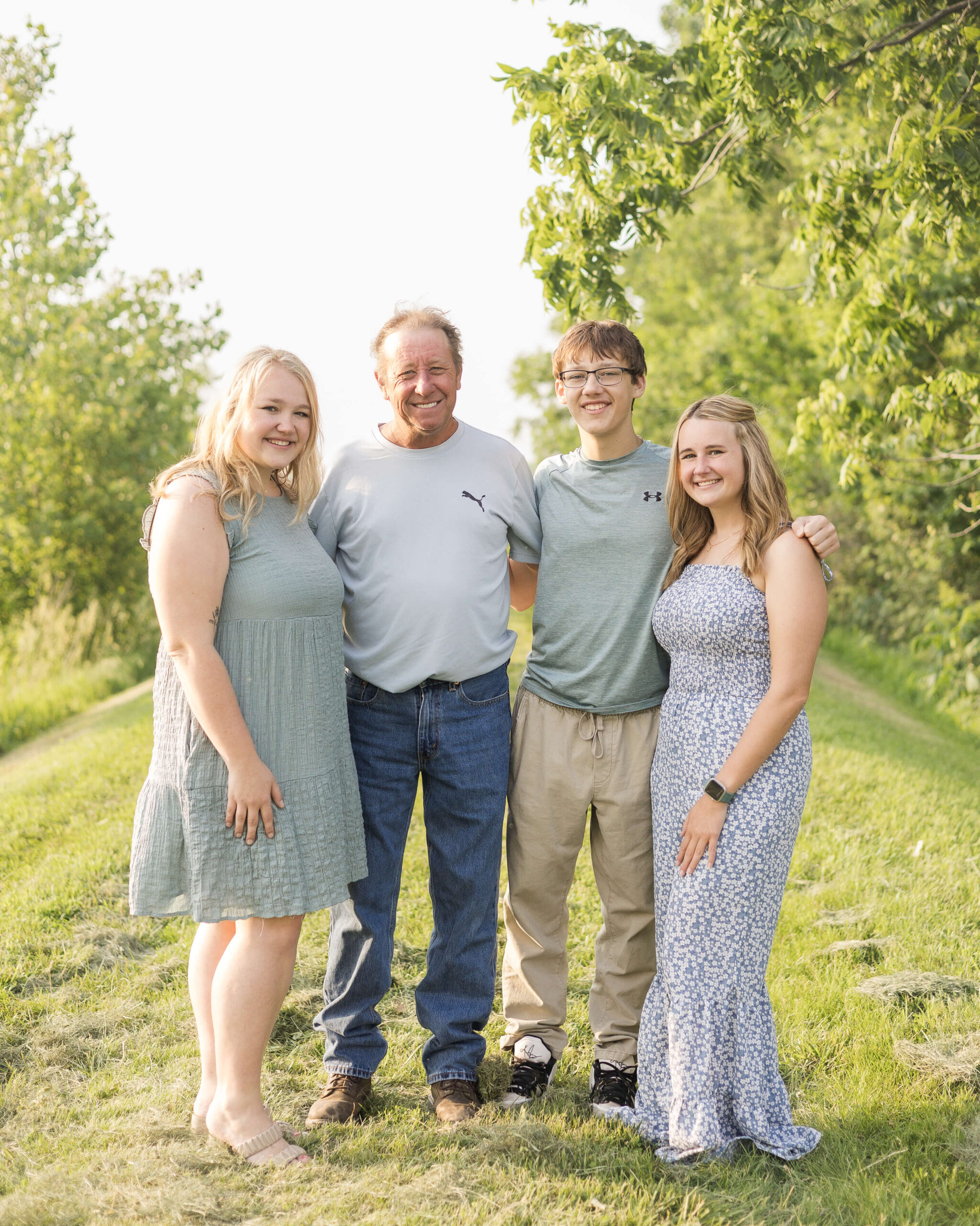 A proud father stands with his three teen children in a park trail after enjoying route 66 restaurant in springfield il